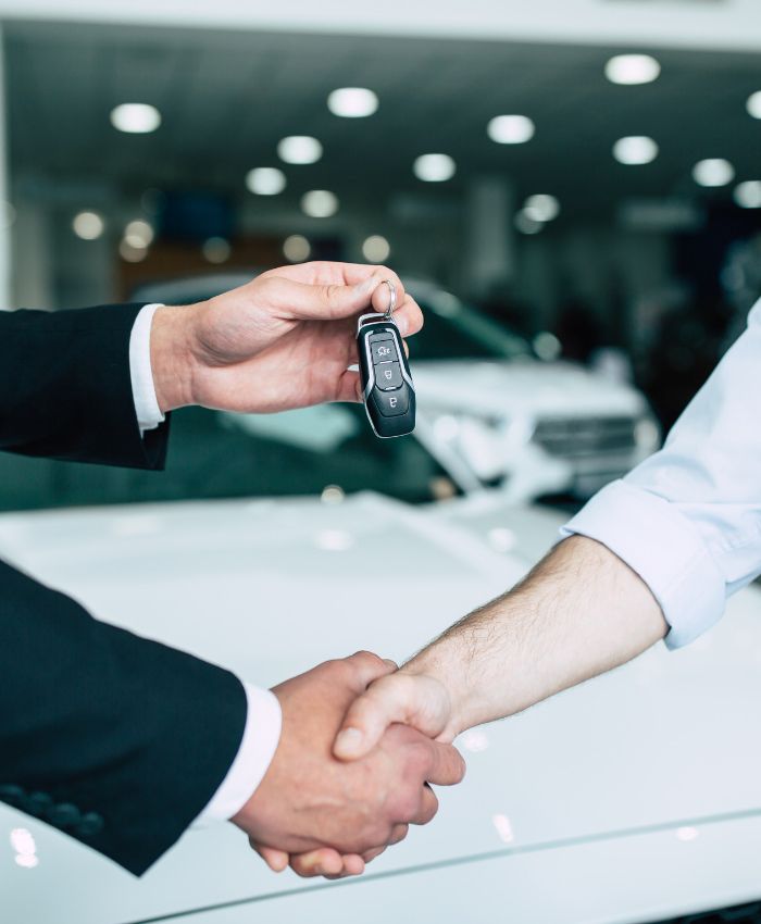 a man handing a car key to another man - business car loan