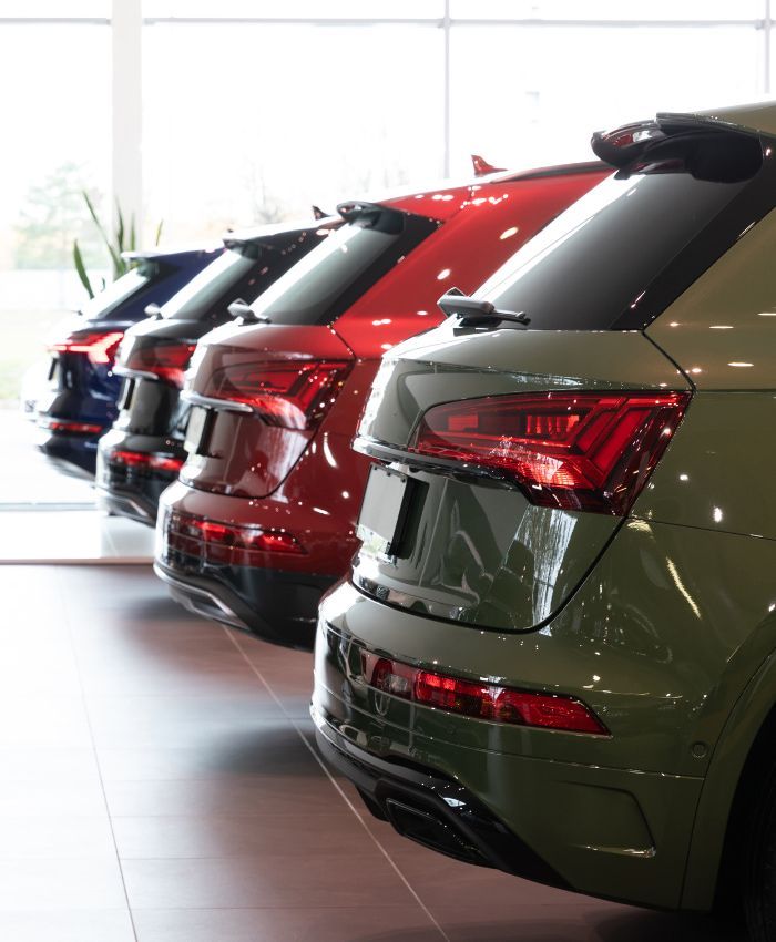 a row of cars are lined up in a showroom - business car loan