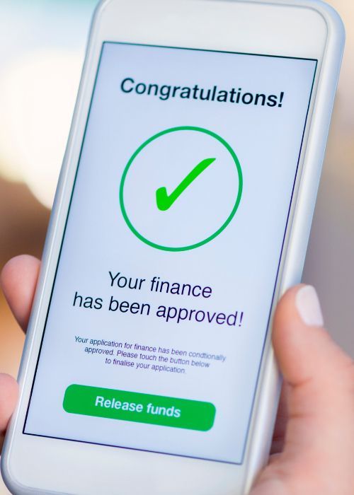 A person is holding a cell phone that says congratulations your finance has been approved