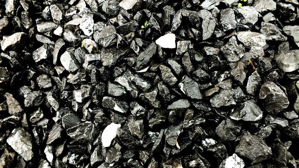 A Pile Of Black Rocks Sitting On Top Of Each Other On The Ground — HKL Landscape Supplies in Coolongoolook, NSW
