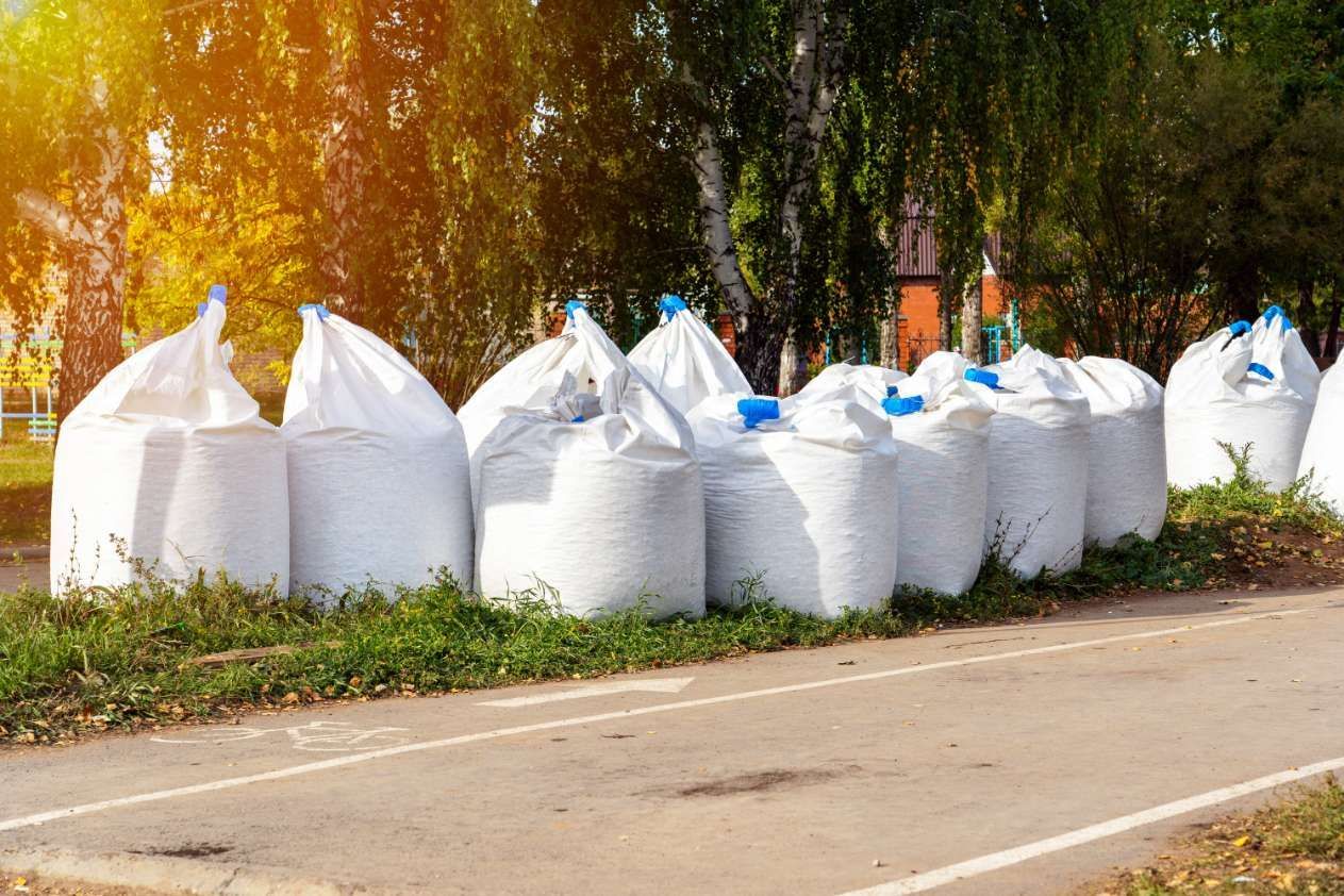 A Row Of White Bags Sitting On The Side Of A Road — HKL Landscape Supplies in Old Bar, NSW