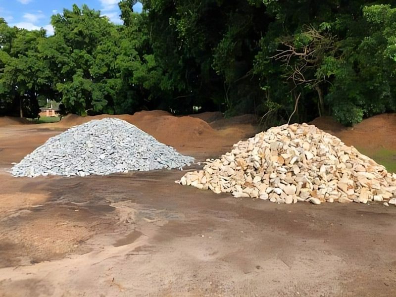 Two Piles of Gravel Are Sitting Next to Each Other in a Dirt Field — HKL Landscape Supplies in Wingham, NSW