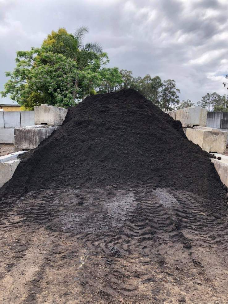A Large Pile of Black Dirt is Sitting on the Ground in a Field — HKL Landscape Supplies in Hallidays Point, NSW