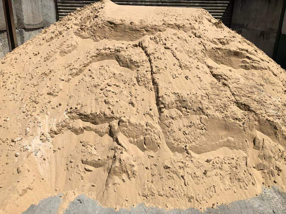 A Pile Of Dirt Is Sitting On The Ground In Front Of A Wooden Fence — HKL Landscape Supplies in Taree South, NSW