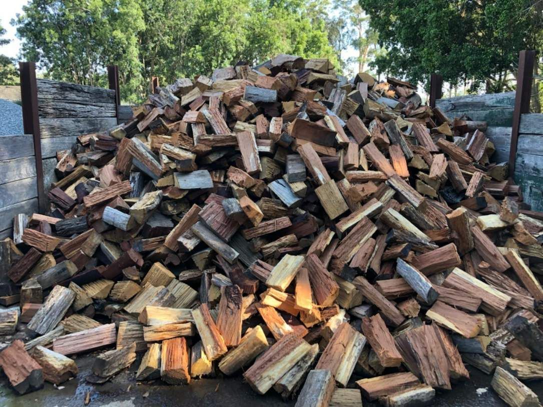 A Pile Of Wood Is Sitting On The Ground In A Yard — HKL Landscape Supplies in Taree South, NSW