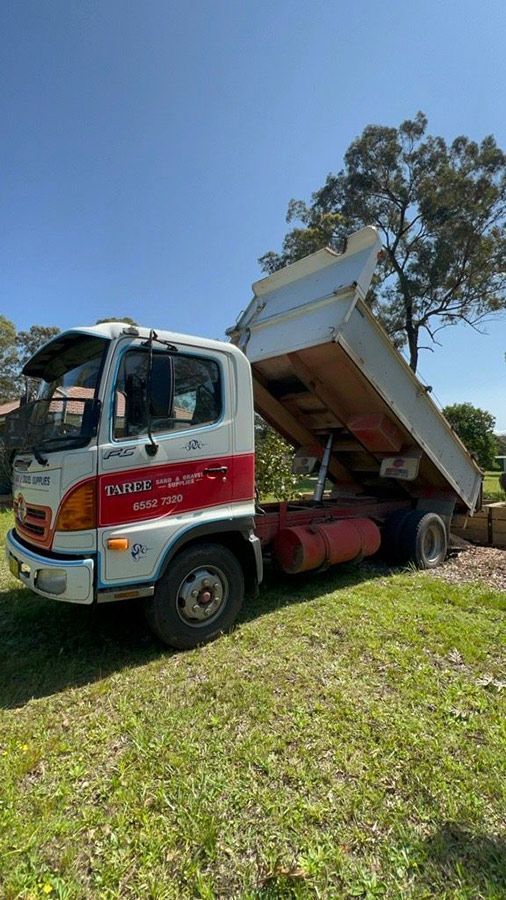 A Dump Truck is Parked in a Grassy Field — HKL Landscape Supplies in Wingham, NSW