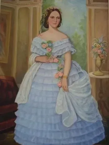 Portrait of a woman in a pale blue ball gown holding flowers in an elegant room