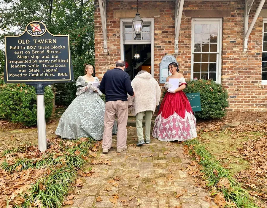 People in colonial-style dress standing at the entrance of Old Tavern museum