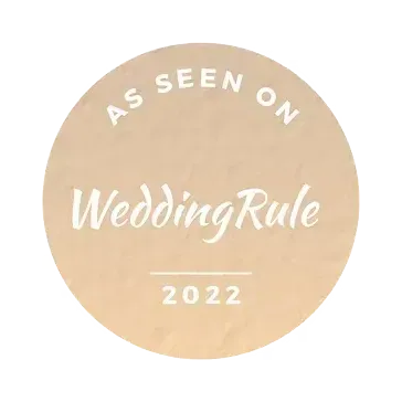 A beige circular badge featuring the white text