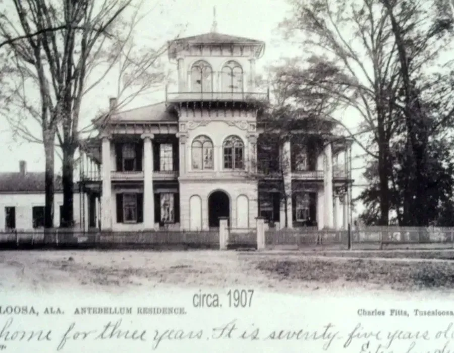 Historic two-story mansion with central tower, front porch, and trees, circa 1907