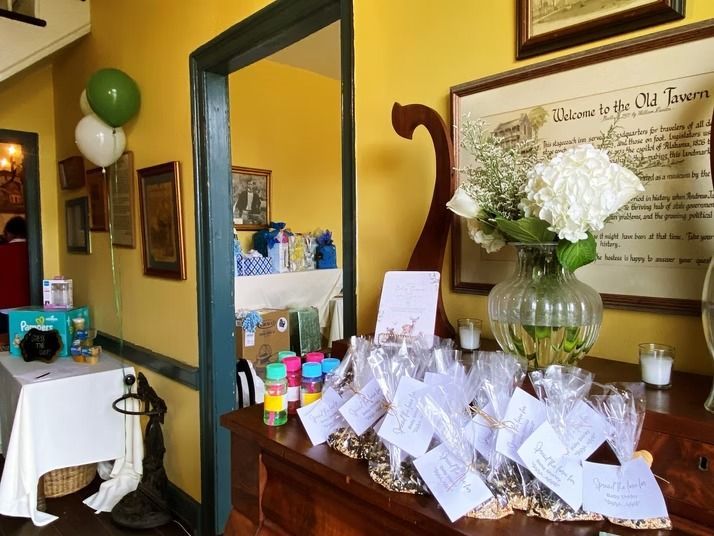 A yellow-walled room with party favors, a flower vase, and gift bags arranged for a celebratory event.
