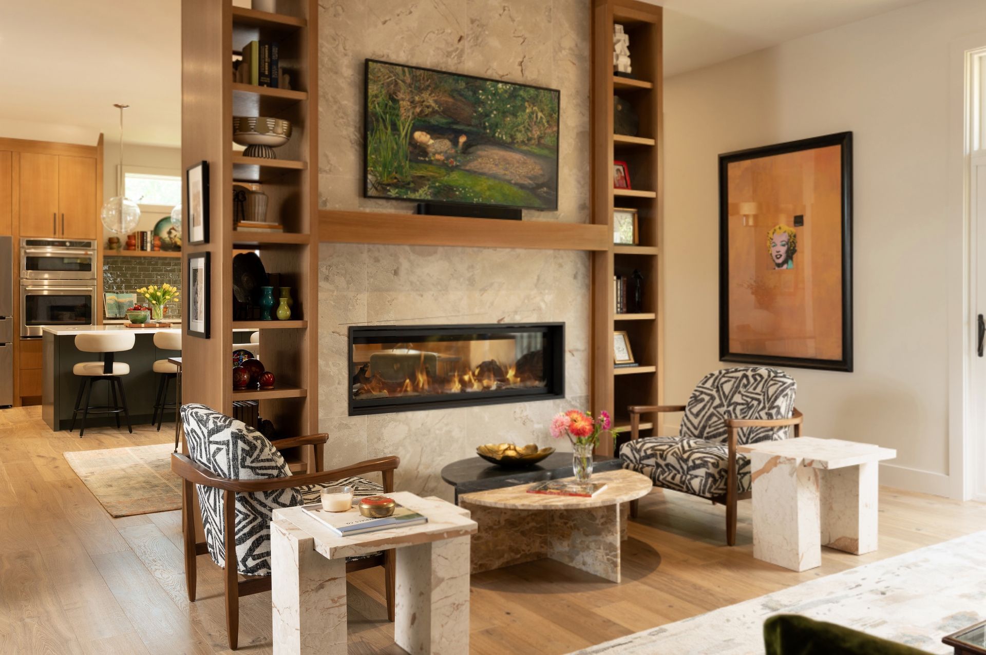 Modern living room with a fireplace, TV, and patterned chairs around a round coffee table