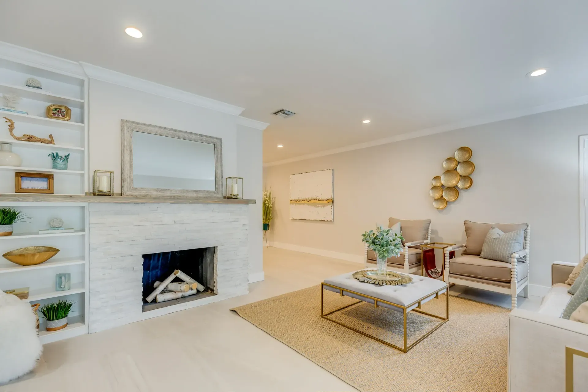 Bright living room with white brick fireplace, beige sofa, and woven coffee table on a light rug.
