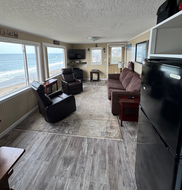 A living room with a couch , chairs , and a television.