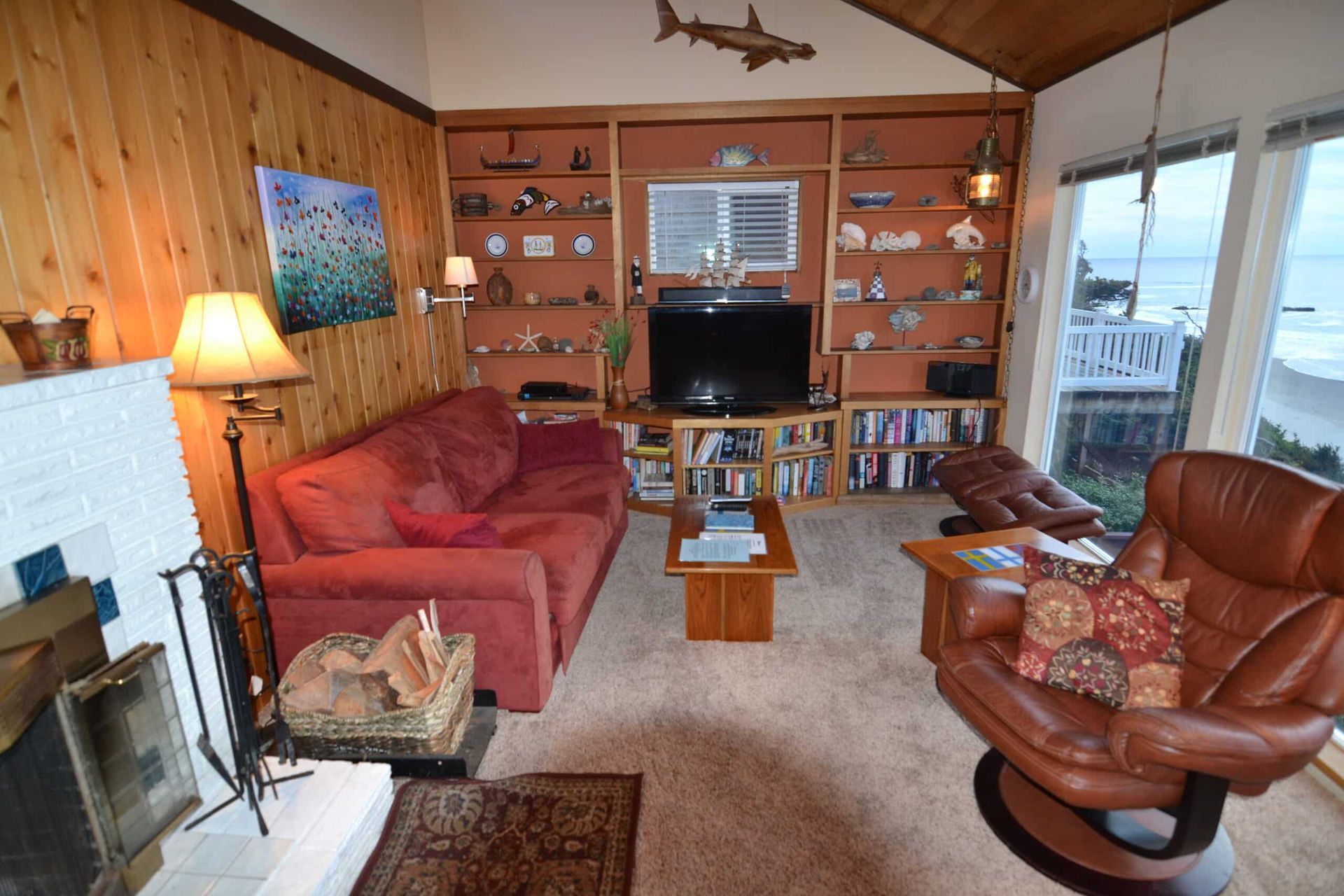 A living room with a red couch and a brown chair
