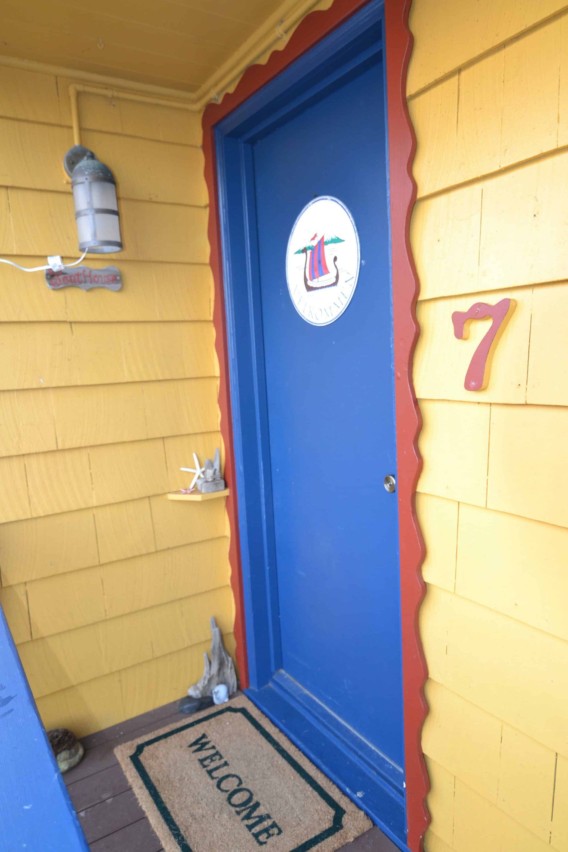 A blue door with a welcome mat in front of it
