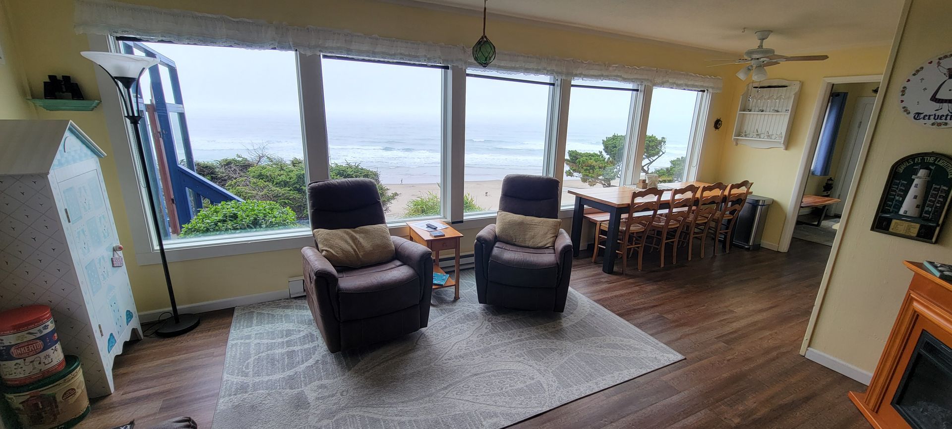 A living room with two chairs and a table with a view of the ocean.