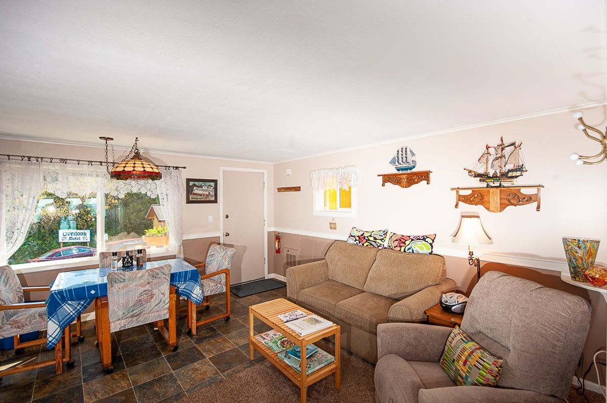 A living room with a couch , chair , table and window.