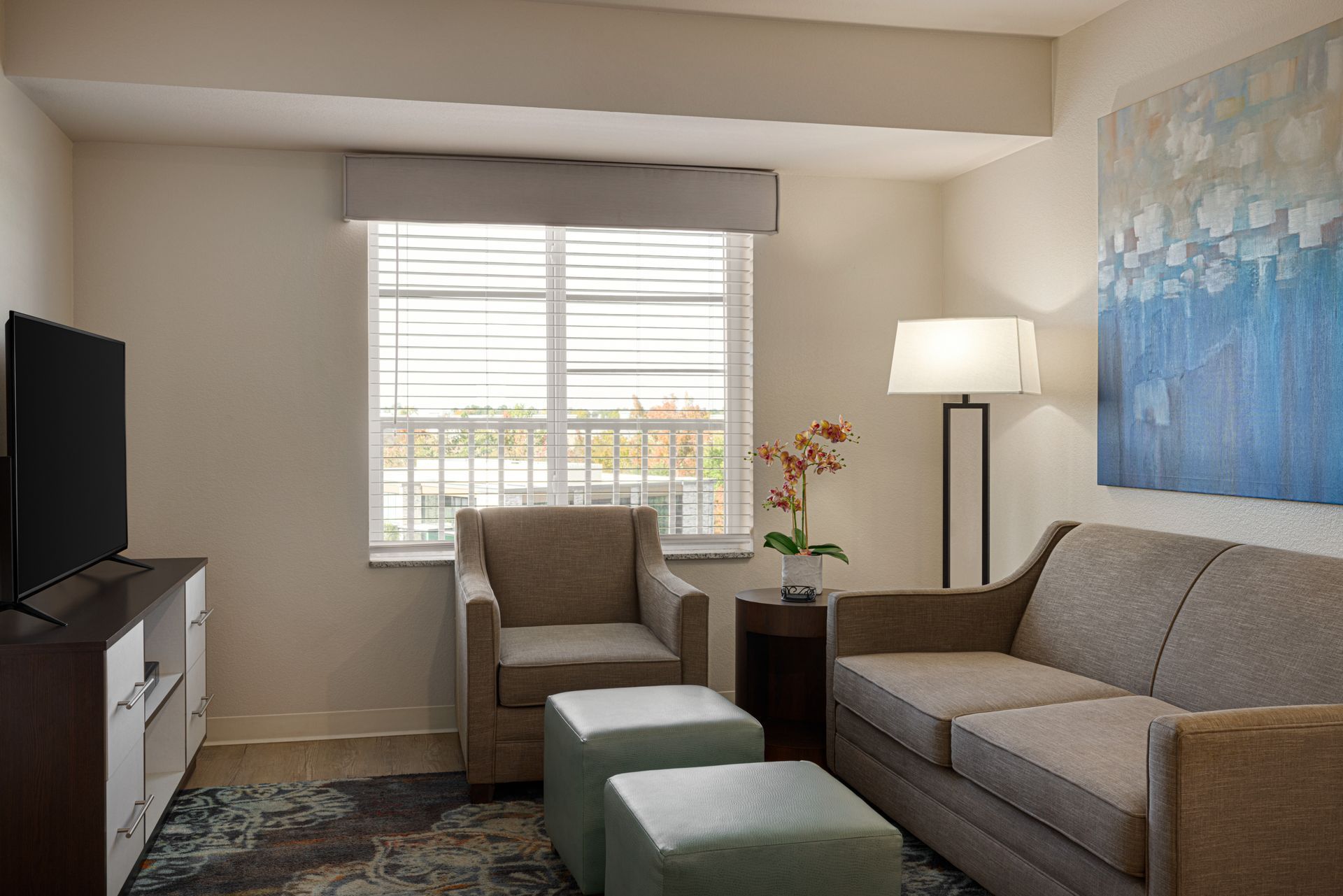 A living room with a couch , chair , and television.