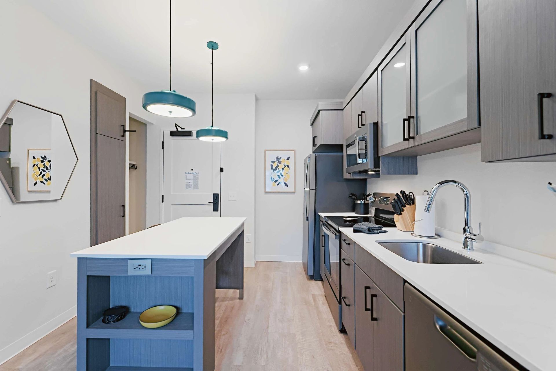 A kitchen with stainless steel appliances and a large island.