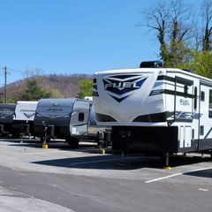 a row of recreational vehicles are parked in a parking lot