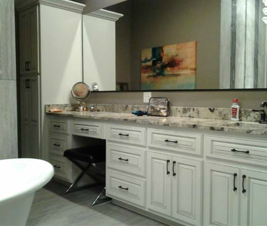 White kitchen vanity with marble countertop, drawers, sink, mirror, and decorative painting on the wall