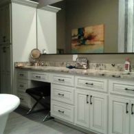 White bathroom vanity with marble countertop, sink, mirror, and wall art in a modern bathroom