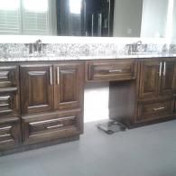 Dark wood bathroom vanity with a central sink cutout and gray floor beneath.