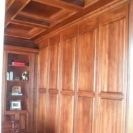 Wood-paneled built-in cabinets and shelves in a warm-toned room.