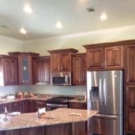 Modern kitchen with dark wood cabinets, stainless steel appliances, and a granite island countertop