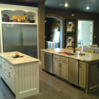 Modern kitchen with a central island, stainless steel fridge, and white cabinets