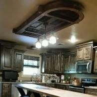 Modern kitchen with dark wood cabinets, island, and hanging ceiling lights