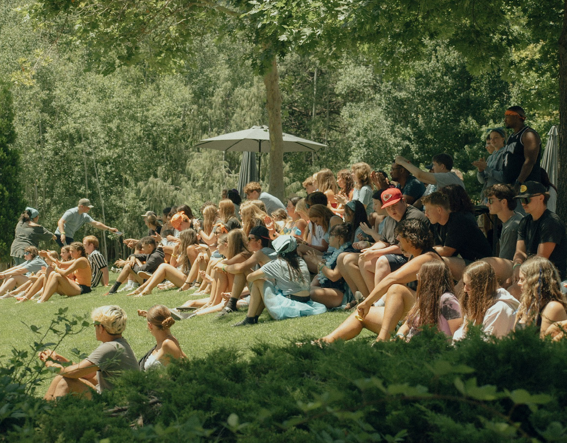 teenage students sitting on the grass