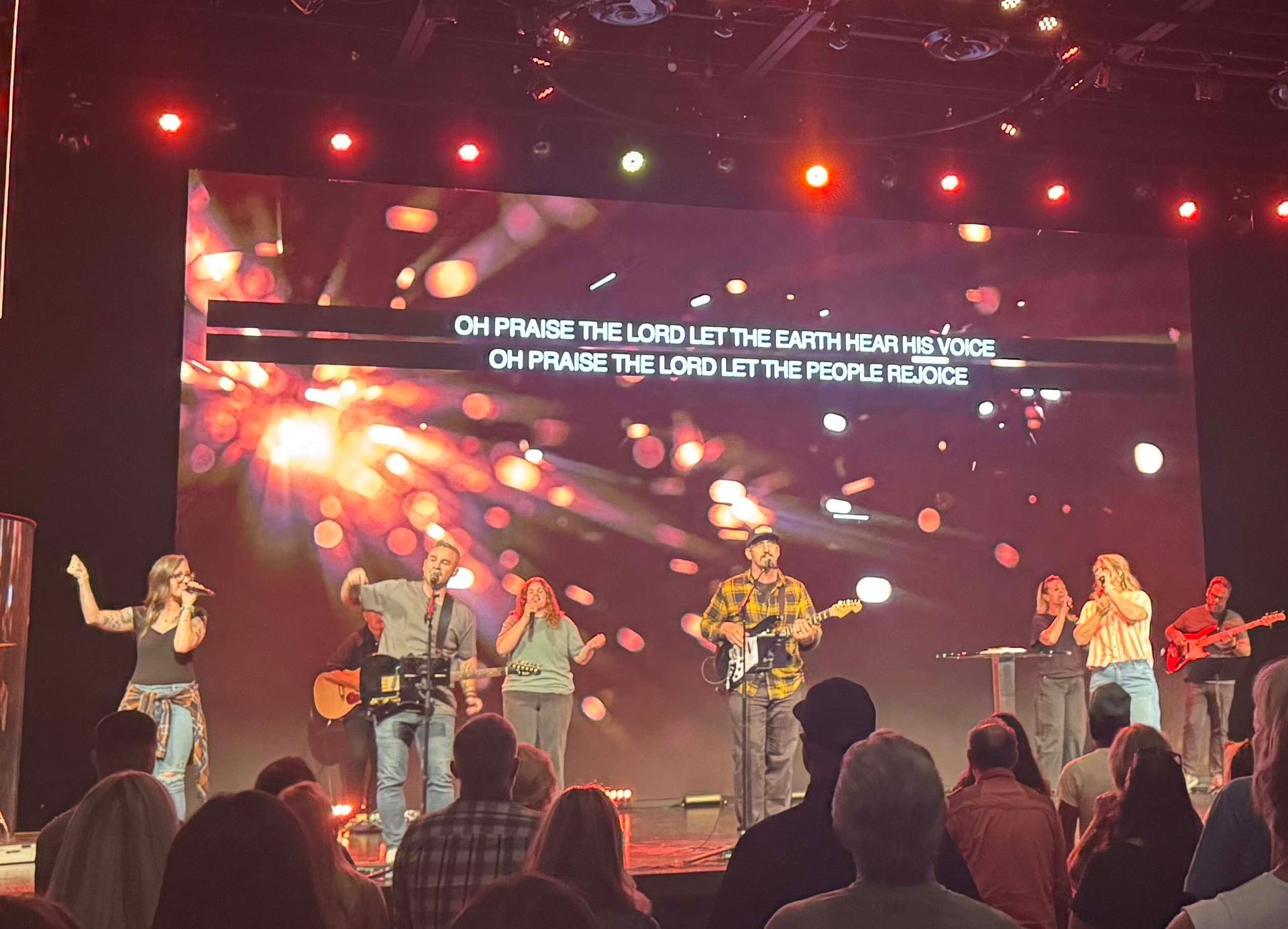 image of people on stage singing and playing instruments