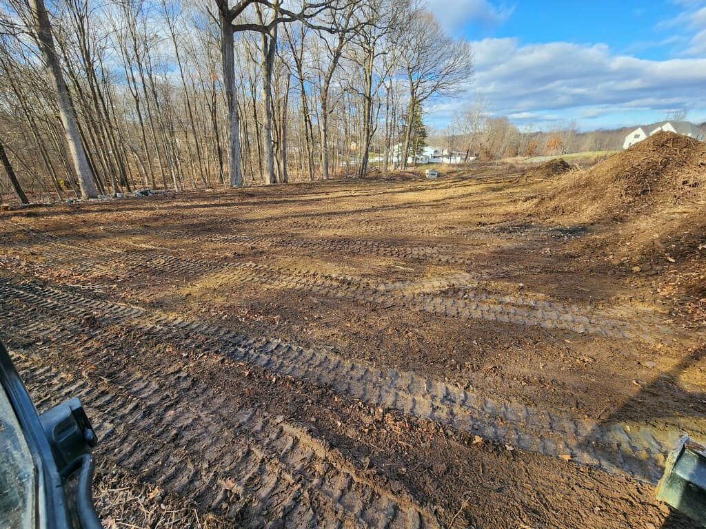 A large pile of dirt is sitting in the middle of a dirt field.
