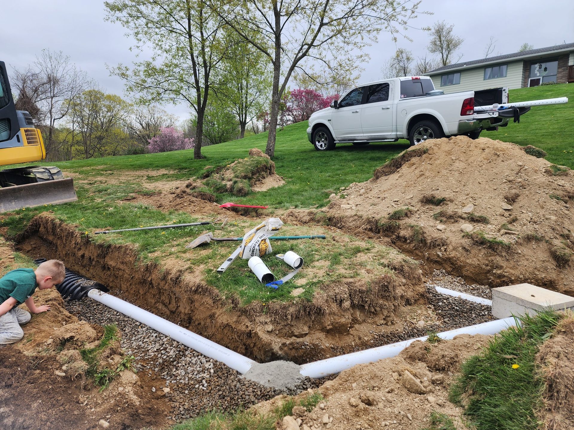 A man is digging a hole in the ground next to a large tank.