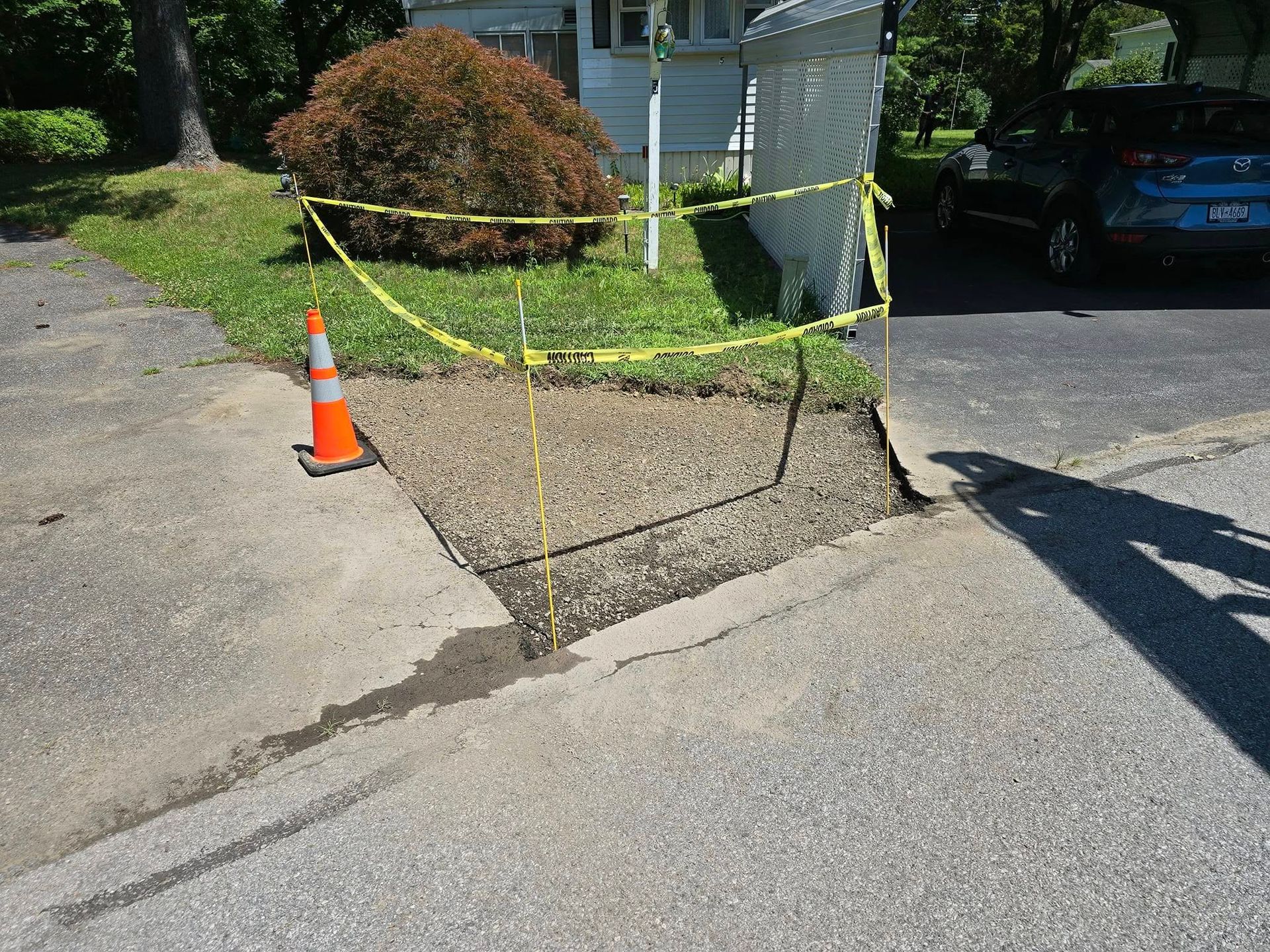 A car is parked on the side of the road next to a concrete curb.