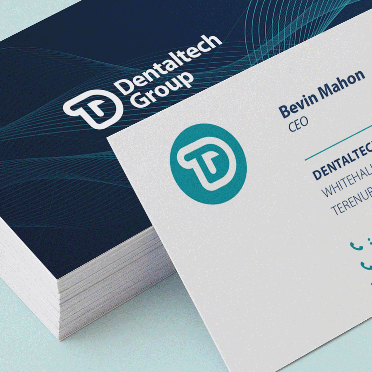 Business cards stacked, one in view. 