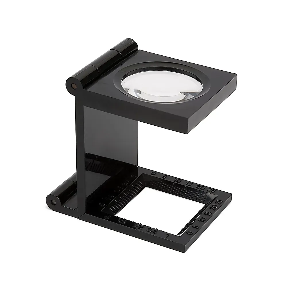 Black stand magnifier with a clear lens and ruler markings.