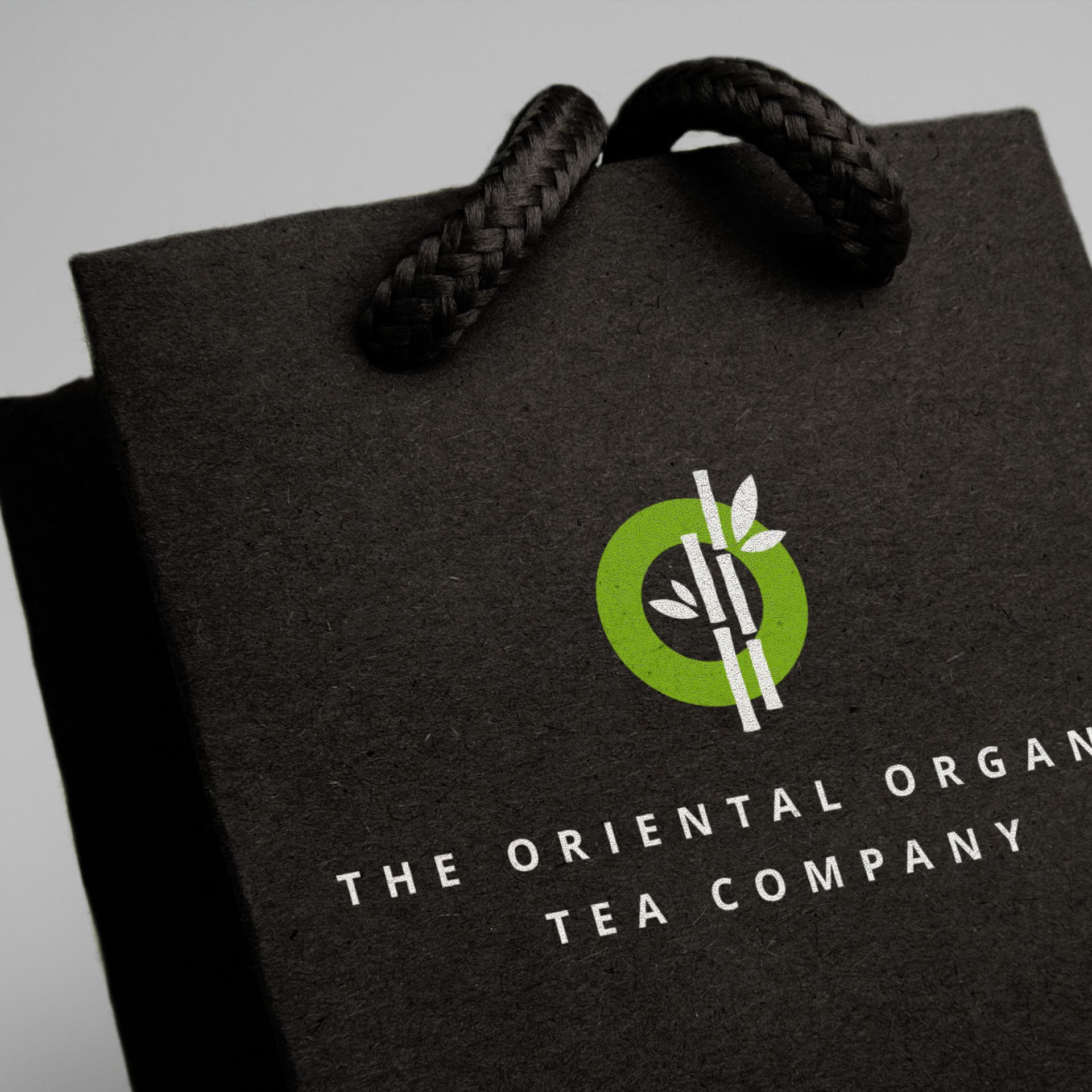 Black paper bag with a logo for