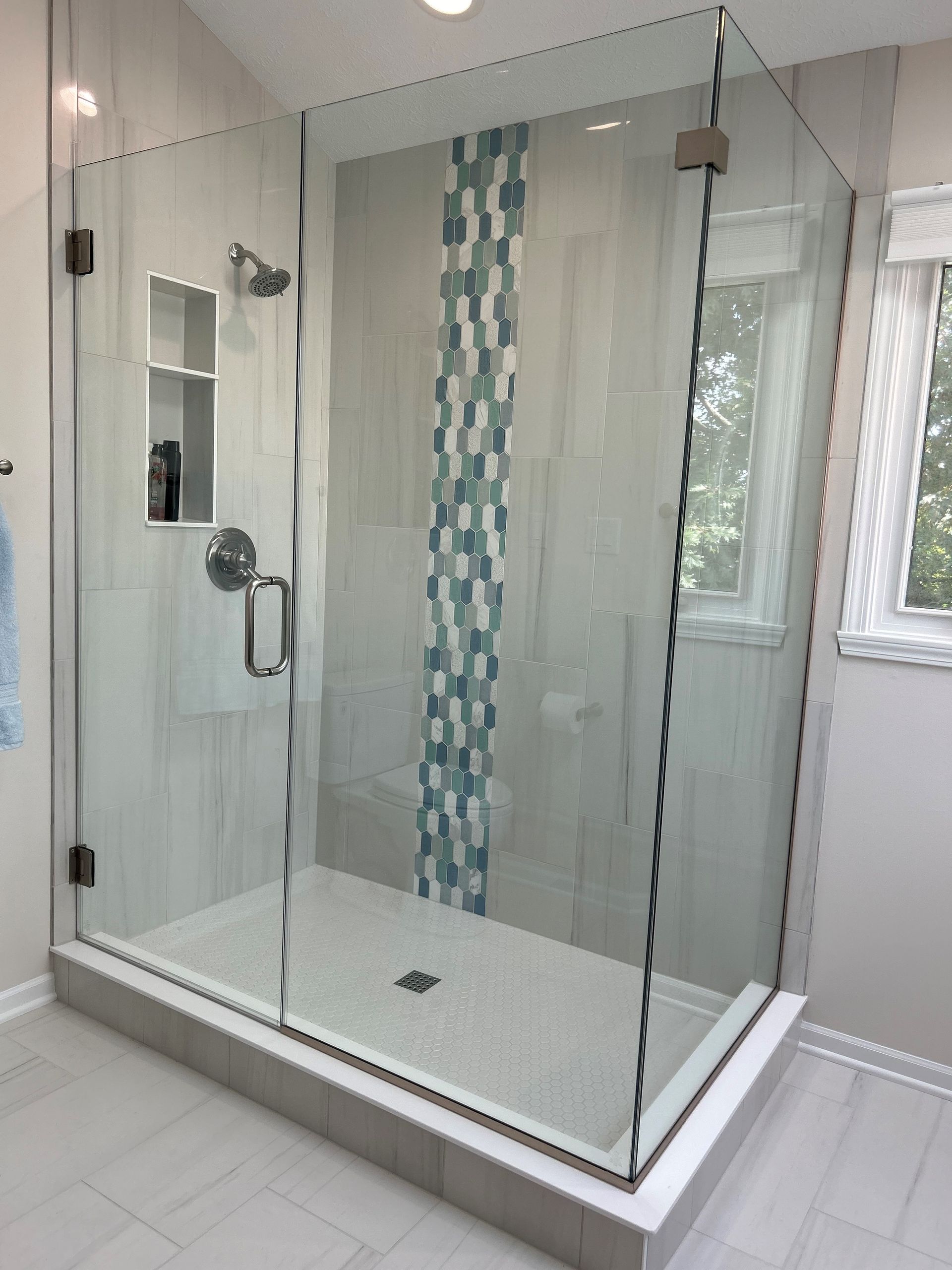 Tiler places a tile on a part of a bathroom floor with cement, as he renovates the space. Tiler places a tile on a part of a bathroom floor with cement, as he renovates the space.