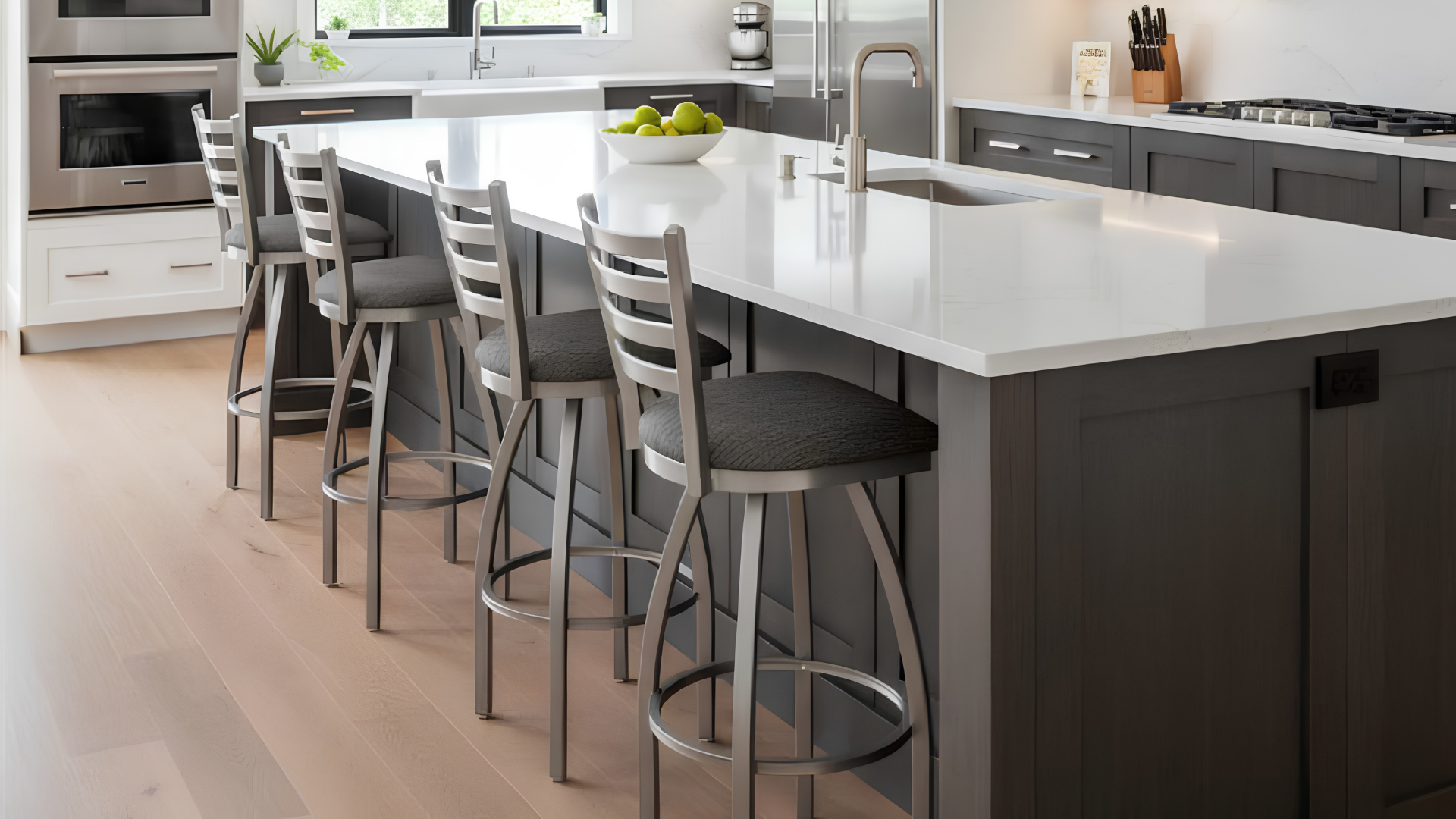 Modern kitchen with white island, bar stools, and stainless steel appliances