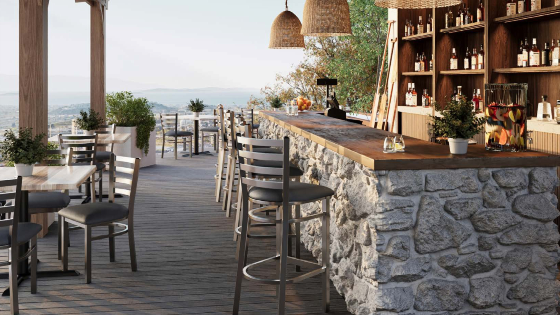 Open-air seaside bar with stone counter, stools, and tables overlooking the water
