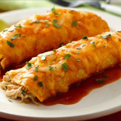 Two enchiladas topped with sauce and herbs on a white plate