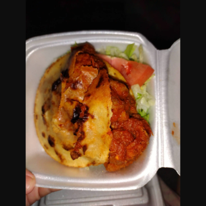 Takeout container with grilled chicken, mashed potatoes, and lettuce-tomato salad