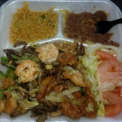 Takeout meal tray with rice, meat and vegetables, shrimp, and sliced tomatoes and lettuce
