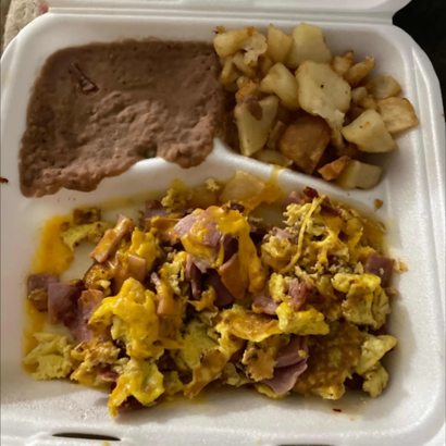 Foam takeout tray with refried beans, diced potatoes, and scrambled eggs with ham
