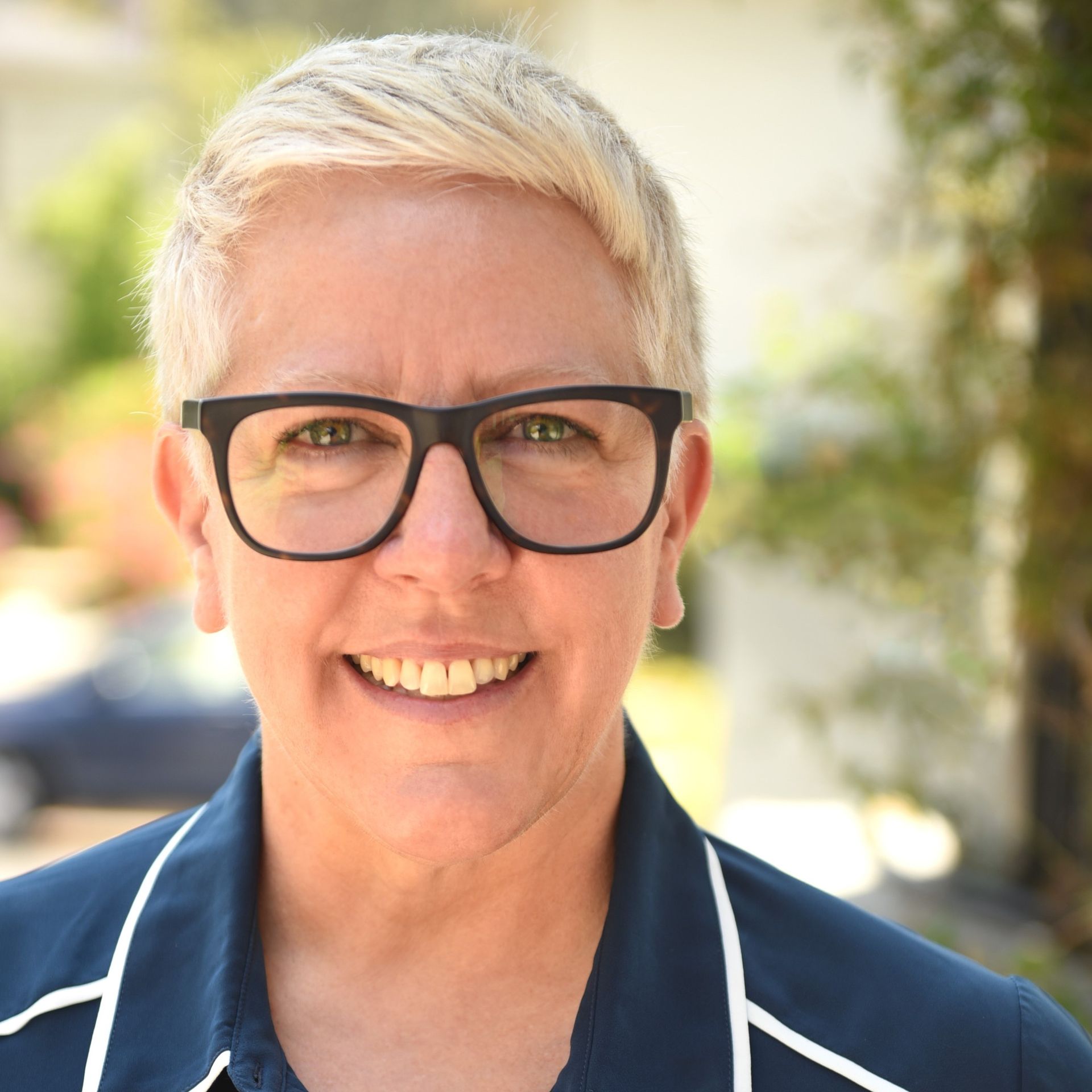 a woman wearing glasses and a blue shirt smiles for the camera | BXB3 Corporation | Archive Solutions in CA