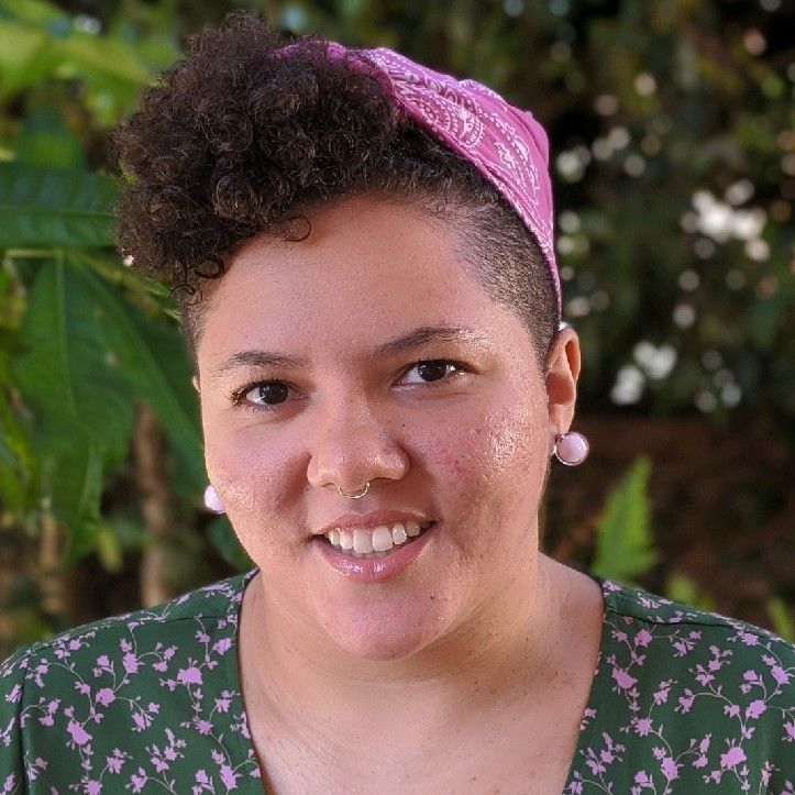 a woman wearing a pink bandana and earrings is smiling for the camera | BXB3 Corporation | Archive Solutions in CA