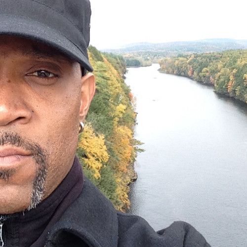 a man in a black hat stands in front of a river | BXB3 Corporation | Archive Solutions in CA